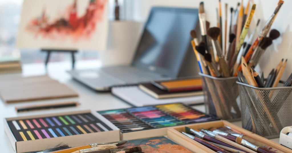 creative business art supplies lined up on a table with a computer.