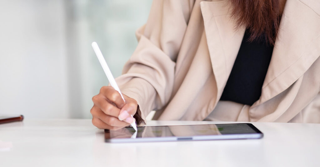 gifts for graphic designers: iPad. Image depicts a woman drawing on an iPad with Apple pencil.
