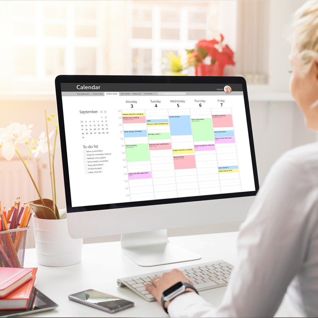 woman at desk with her promotional calendar open on her computer.