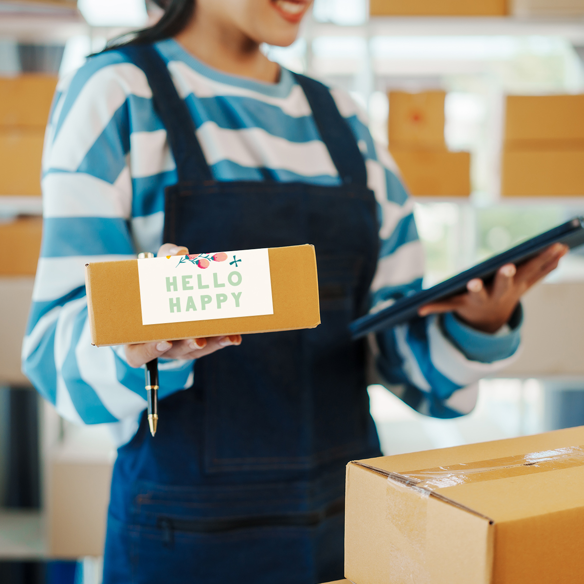 Image shows a woman holding a package surrounded by shelves of boxes.