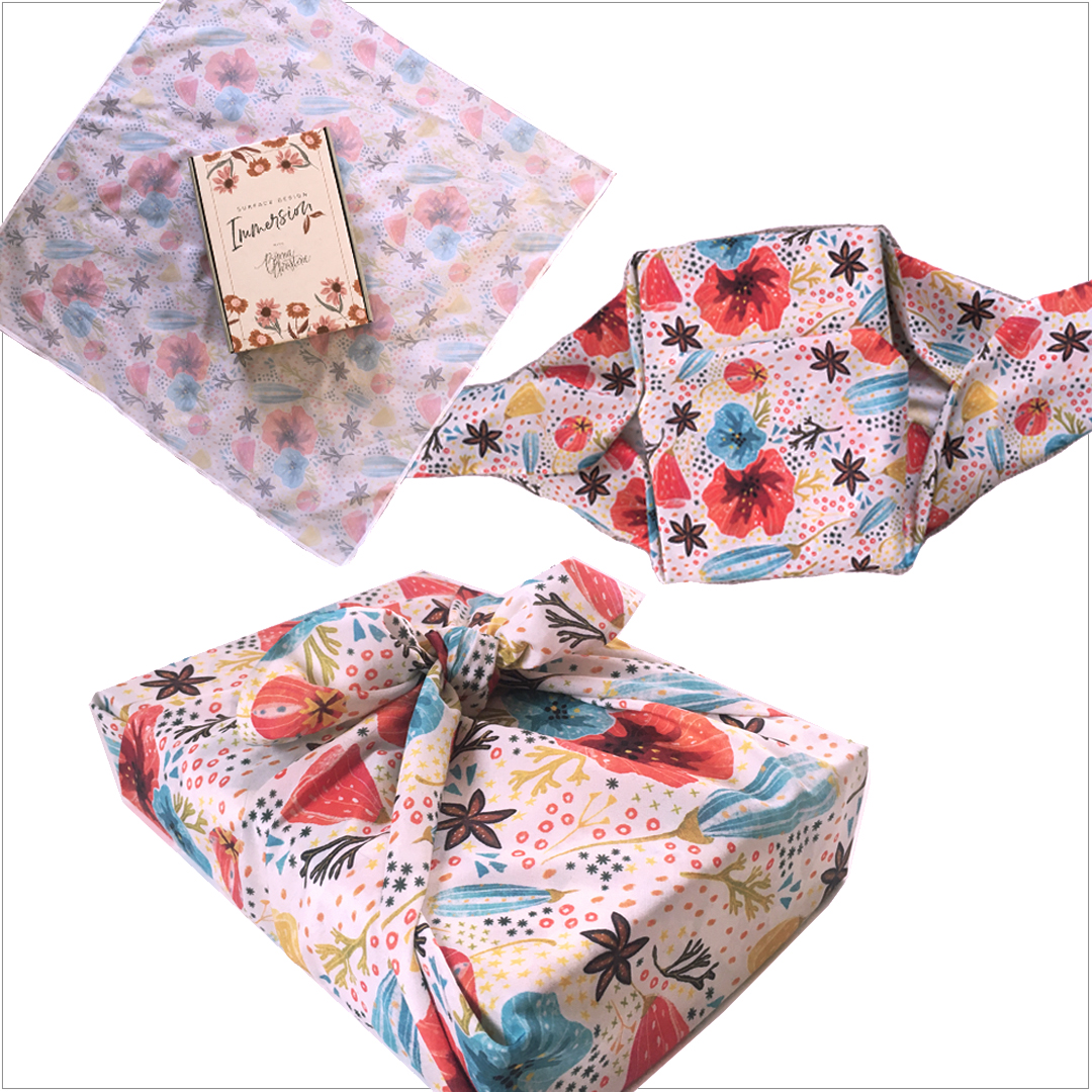 image shows a box being wrapped in a fabric scarf in the furoshiki fabric gift wrapping method. 