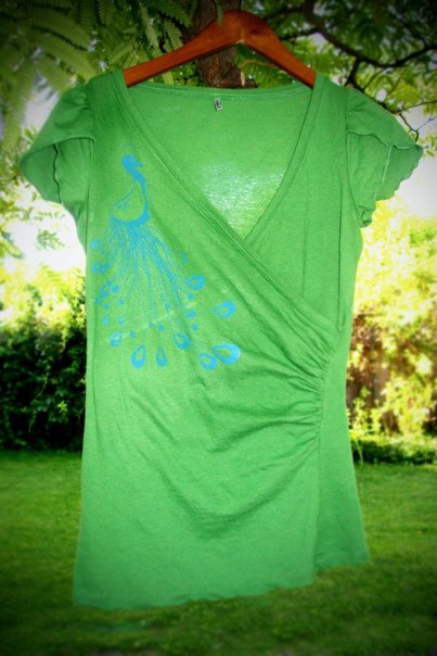 image of artist made green t shirt with screen print of blue peacock.