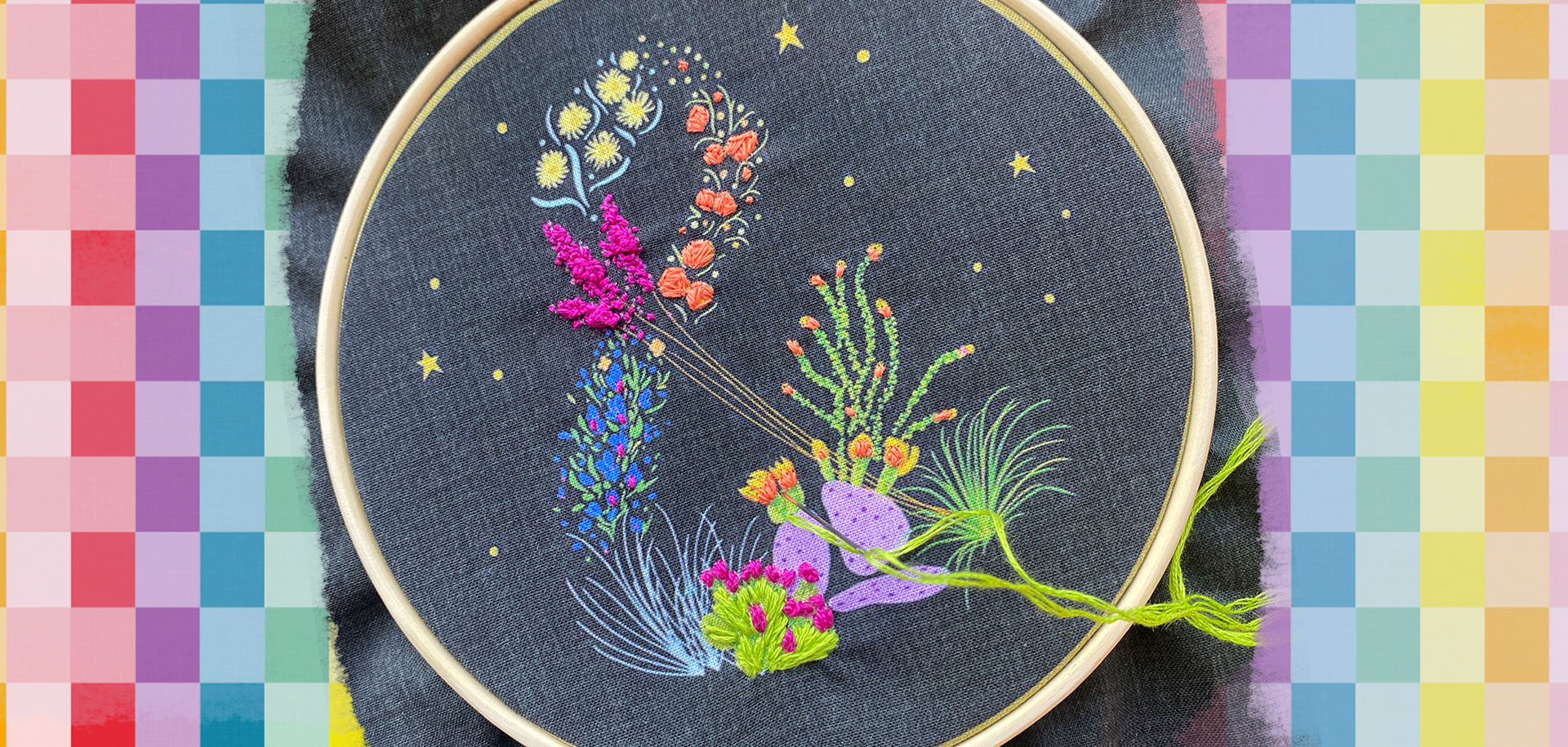 Image shows a cute beginner embroidery kit for sale, featuring a black cloth with an ampersand printed on it with wild desert flowers.